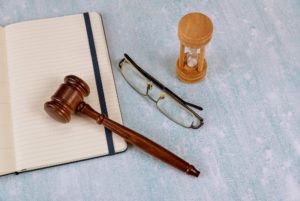 Time management hourglass with sand on a auction wooden gavel